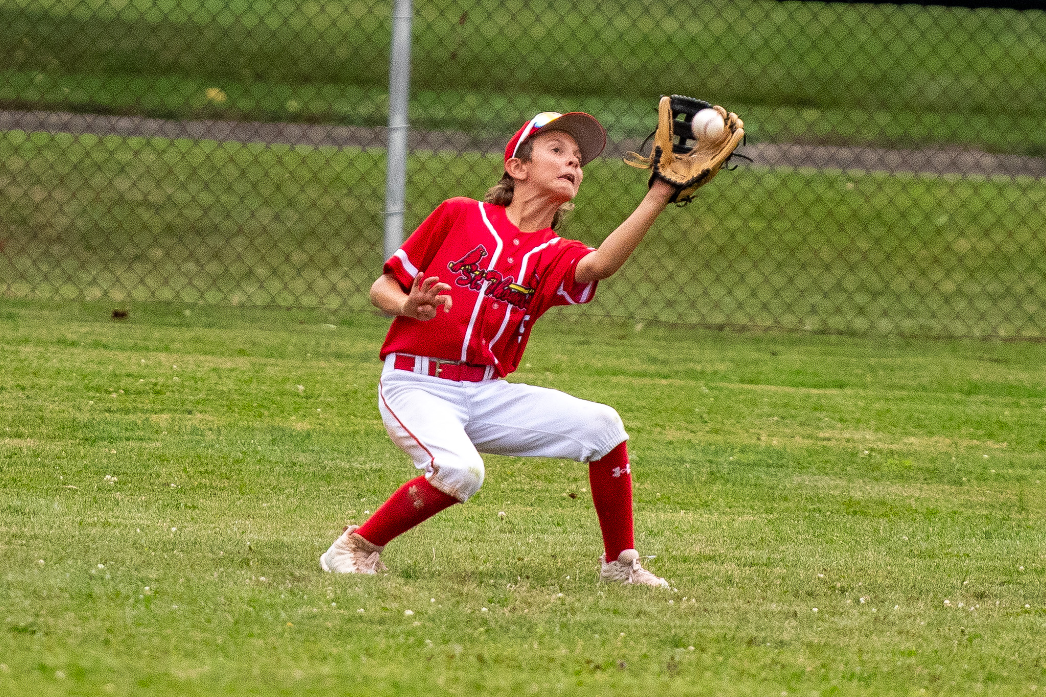St. Thomas Cardinals outfielder Zion Gibbons tracks down a fly ball