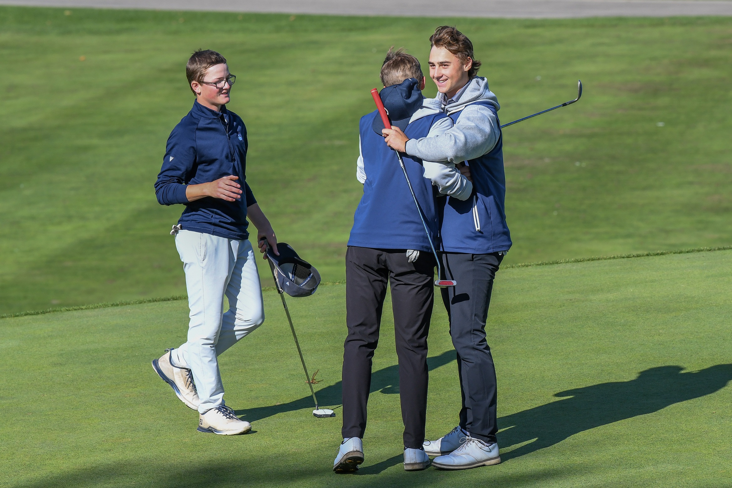 Mitchell District's Oliver Watt, left and Parkside Stampeders Jacob Bosma, right, congratulate Stampeders Preston Gryp on winning the playoff hole for WOSSAA gold.