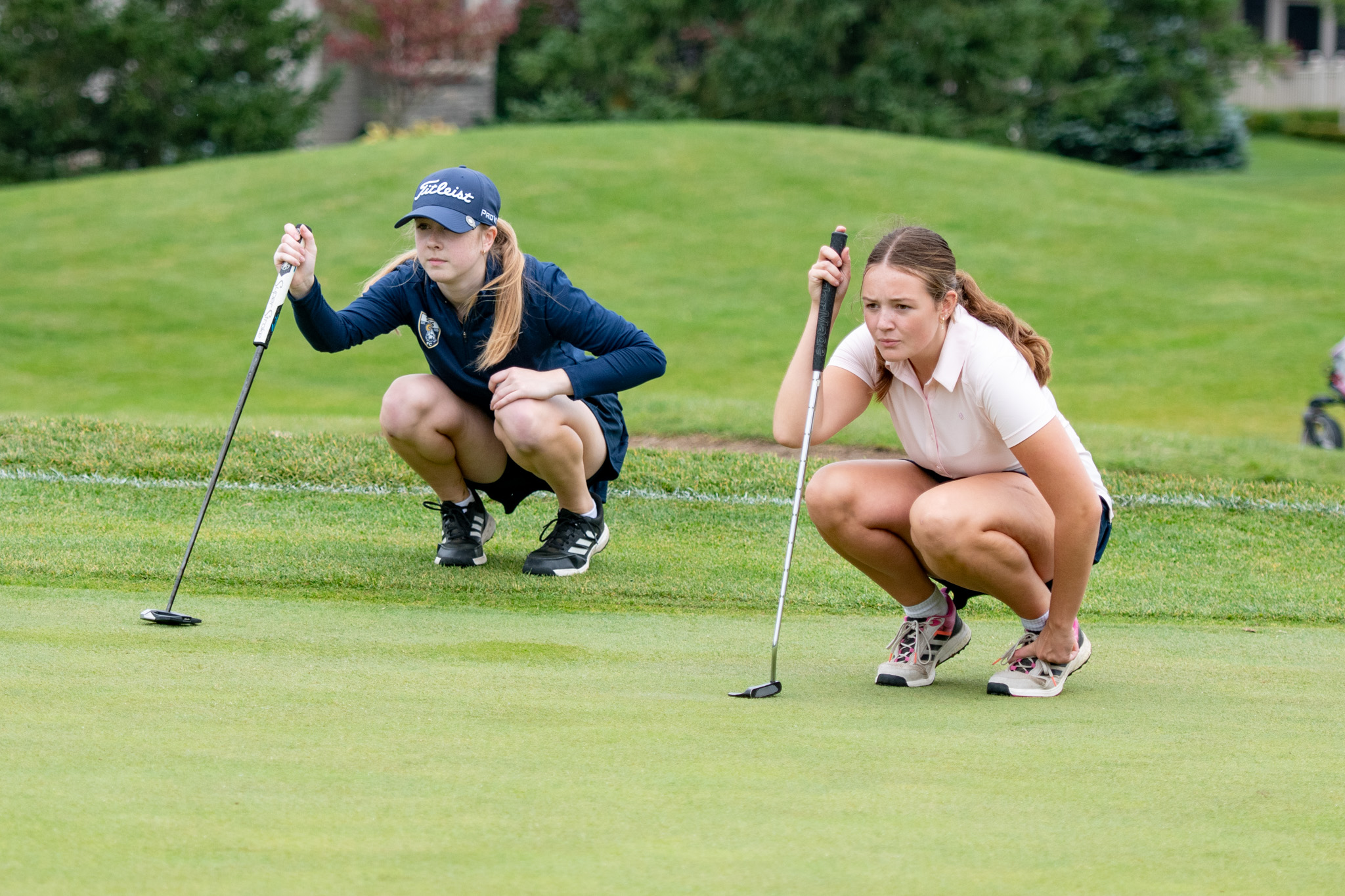 Melissa Gillies, left, and St. Mike's Bella Rae, examine the greens for best shot to the hole.